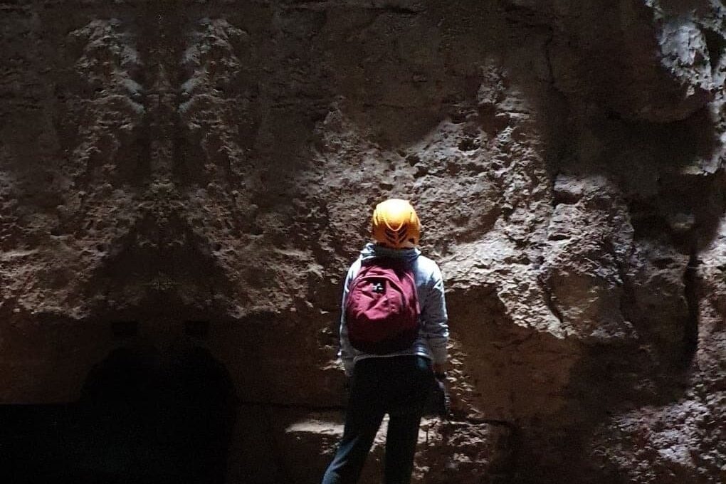 visitante admirando la Gruta del Duende